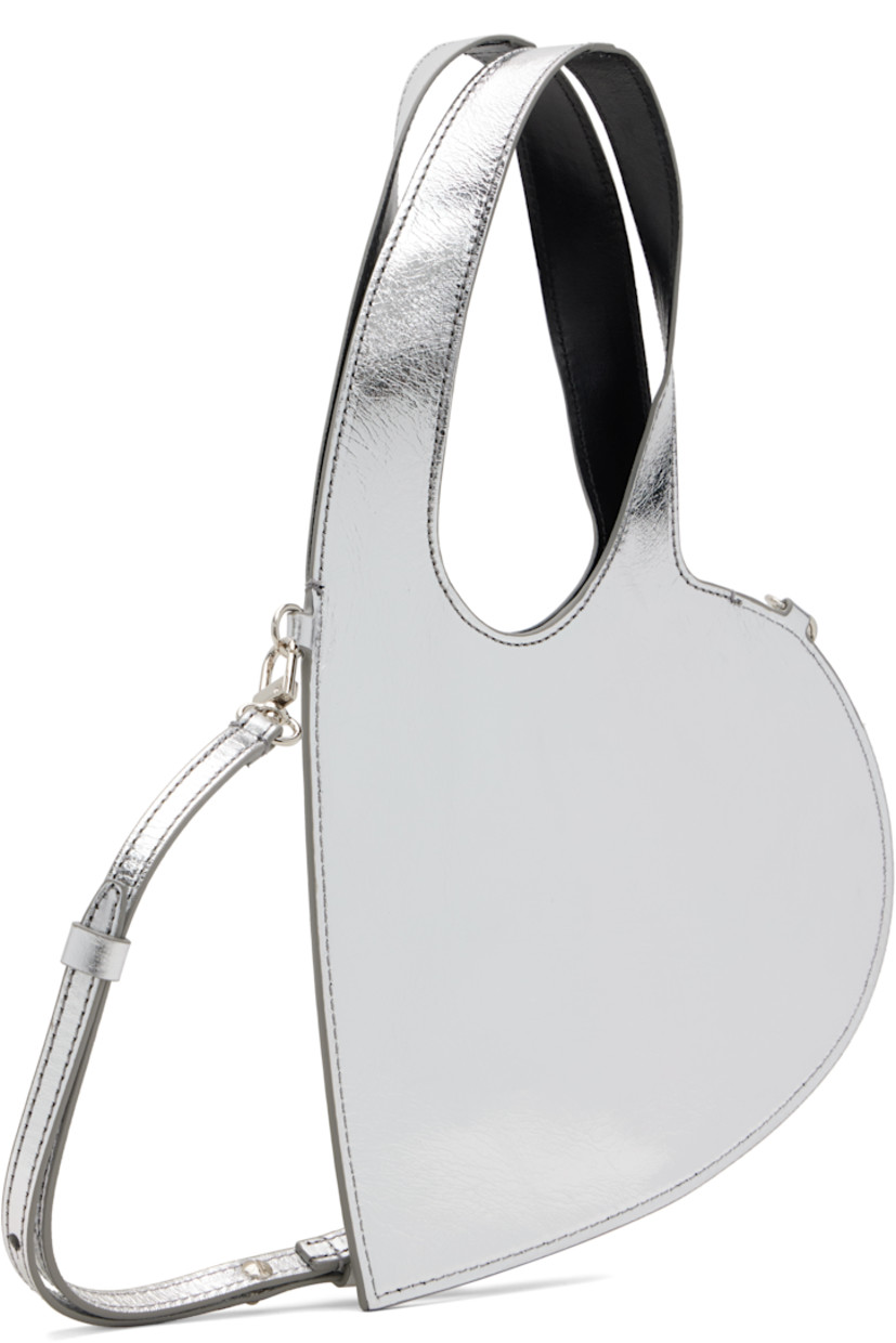Heart-shaped crinkled patent leather shoulder bag.

· Twin carry handles
· Detachable and adjustable crossbody strap
· Logo stamp at face
· Buffed leather lining
· H6.25" x W8"
· Total height: H12"

Supplier color: Silver