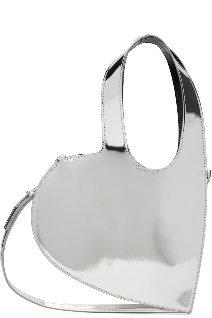 Heart-shaped patent faux-leather messenger bag.

·� Integrated carry handles
· Adjustable and detachable crossbody strap
· H8.5" x W9"
· Total height: H13"

Supplier color: Silver