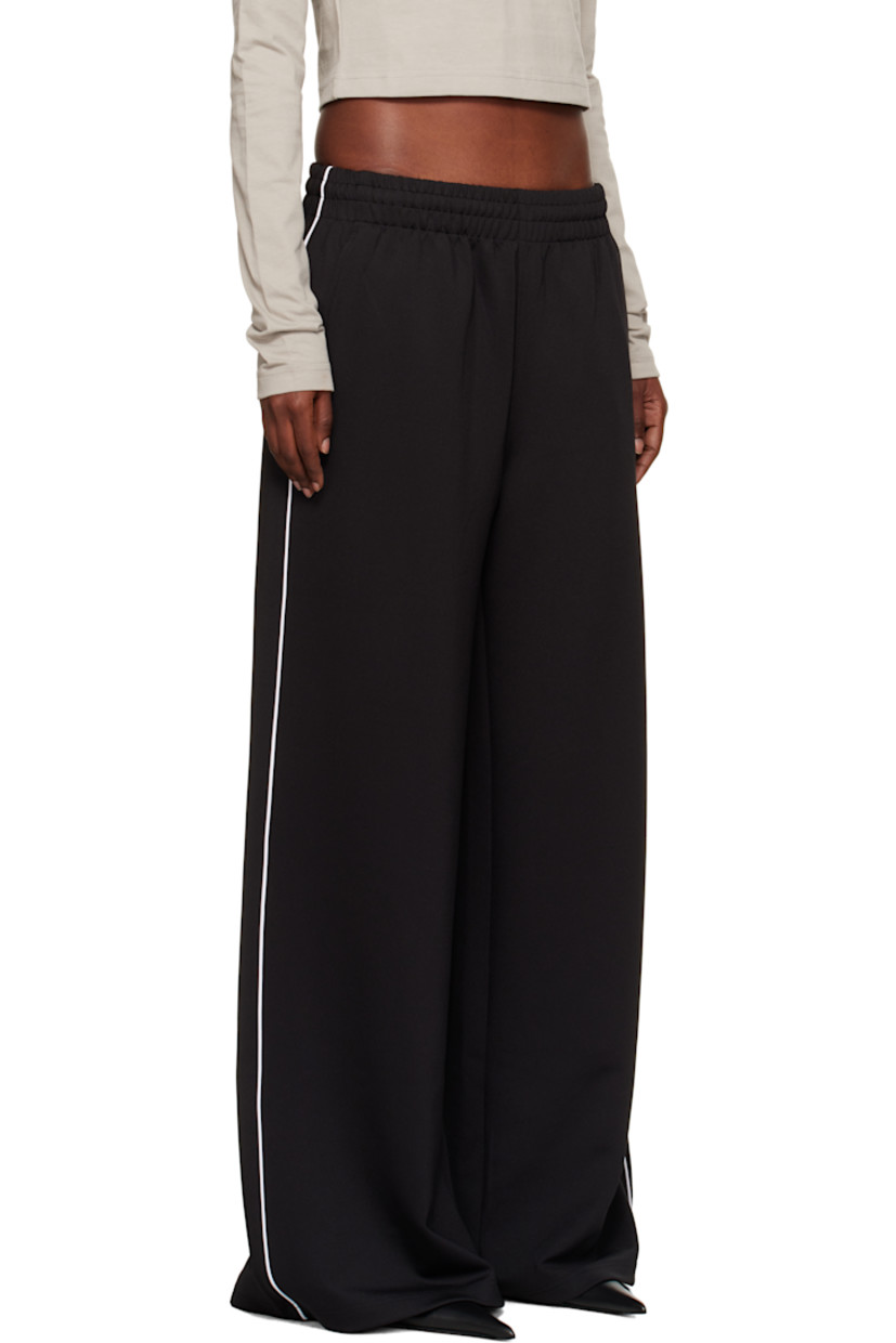 Stretch jersey track pants.

· Flared, wide-leg
· Mid-rise
· Concealed drawstring at elasticized waistband
· Four-pocket styling
· Logo embroidered at front
· Piping at outseams
· Rubberized logo patch at back pocket

Supplier color: Black