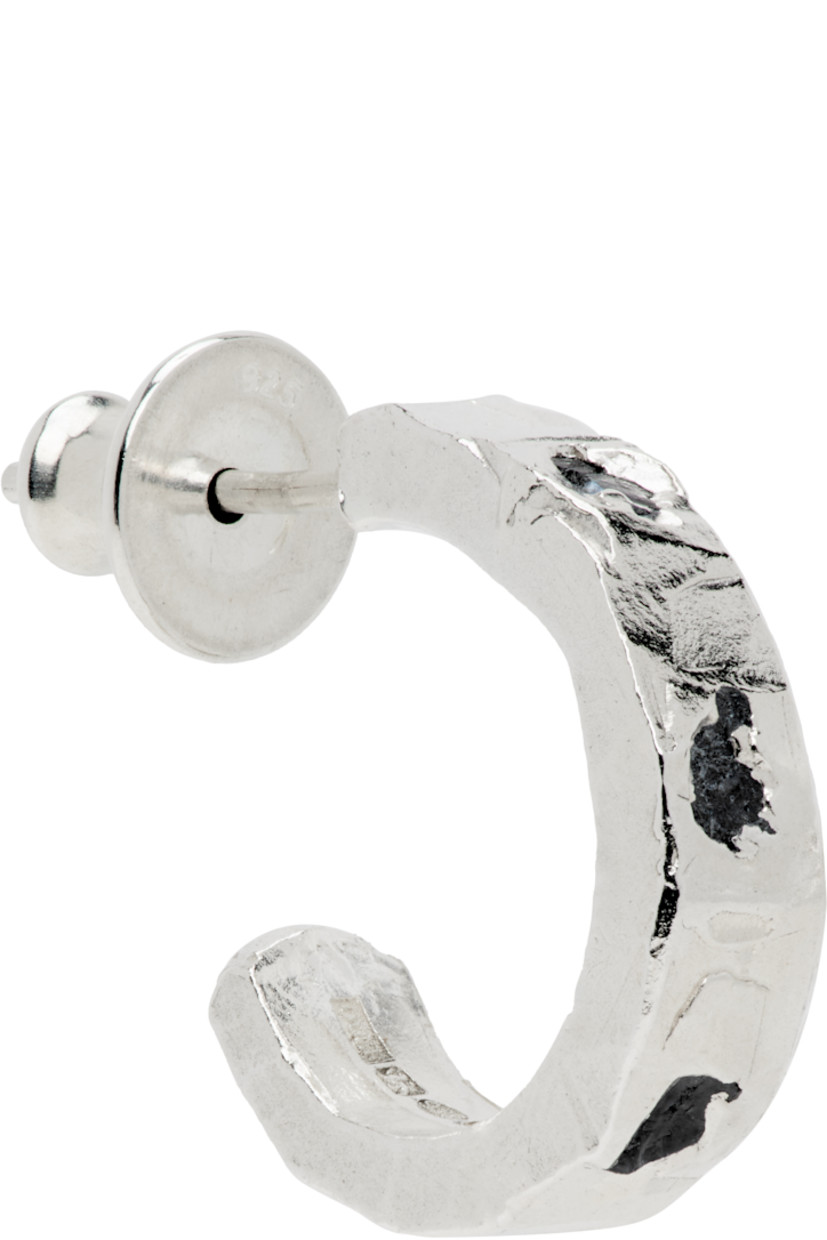 Handcrafted single open hoop earring in sterling silver. 

· Textured detailing throughout 
· Bezel-set 0.7 cttw sapphires at face
· Full hallmarking 
· Post-stud fastening 
· D0.5"

Supplier color: Silver/Sapphire