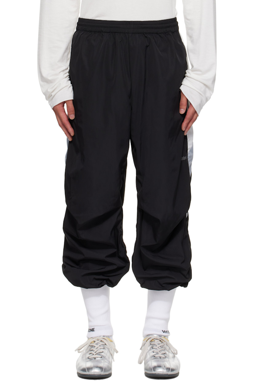 Taffeta track pants.

· Concealed drawstring at elasticized waistband
· Two-pocket styling
· Pleats at knees
· Rib-knit trim with jacquard logo at cuffs
· Stripe appliqués at outseams
· Reflective logo printed at outseam

Supplier color: Black