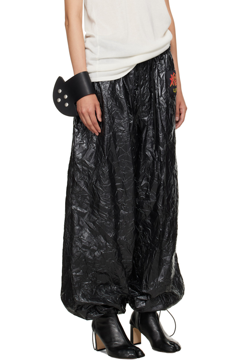 Resin-coated nylon sweatpants.

· Wide-leg 
· Drawstring at elasticized waistband 
· Two-pocket styling
· Button fly  
· Logo patch at front 
· Cord-lock drawstring at cuffs

Supplier color: Black