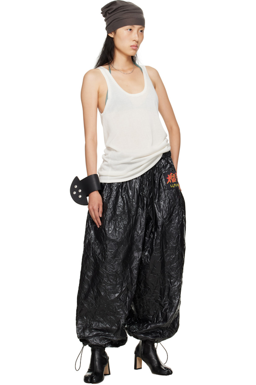 Resin-coated nylon sweatpants.

· Wide-leg 
· Drawstring at elasticized waistband 
· Two-pocket styling
· Button fly  
· Logo patch at front 
· Cord-lock drawstring at cuffs

Supplier color: Black