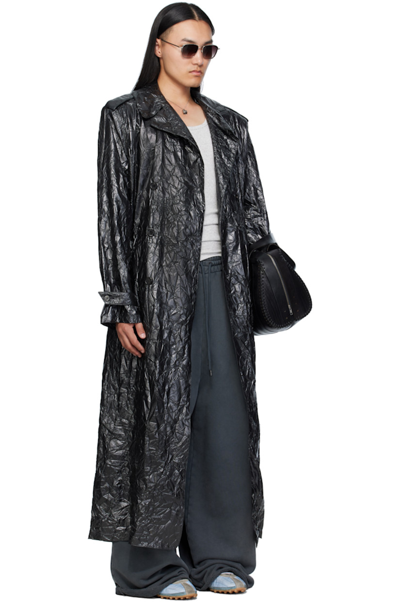 Coated crinkled nylon trench coat. 

· Peaked lapel 
· Double-breasted button closure
· Belt loops and detachable self-tie belt 
· Welt pockets at waist
· Epaulets at padded shoulders
· Central vent at back hem 

Supplier color: Black