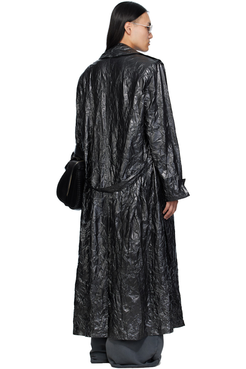 Coated crinkled nylon trench coat. 

· Peaked lapel 
· Double-breasted button closure
· Belt loops and detachable self-tie belt 
· Welt pockets at waist
· Epaulets at padded shoulders
· Central vent at back hem 

Supplier color: Black