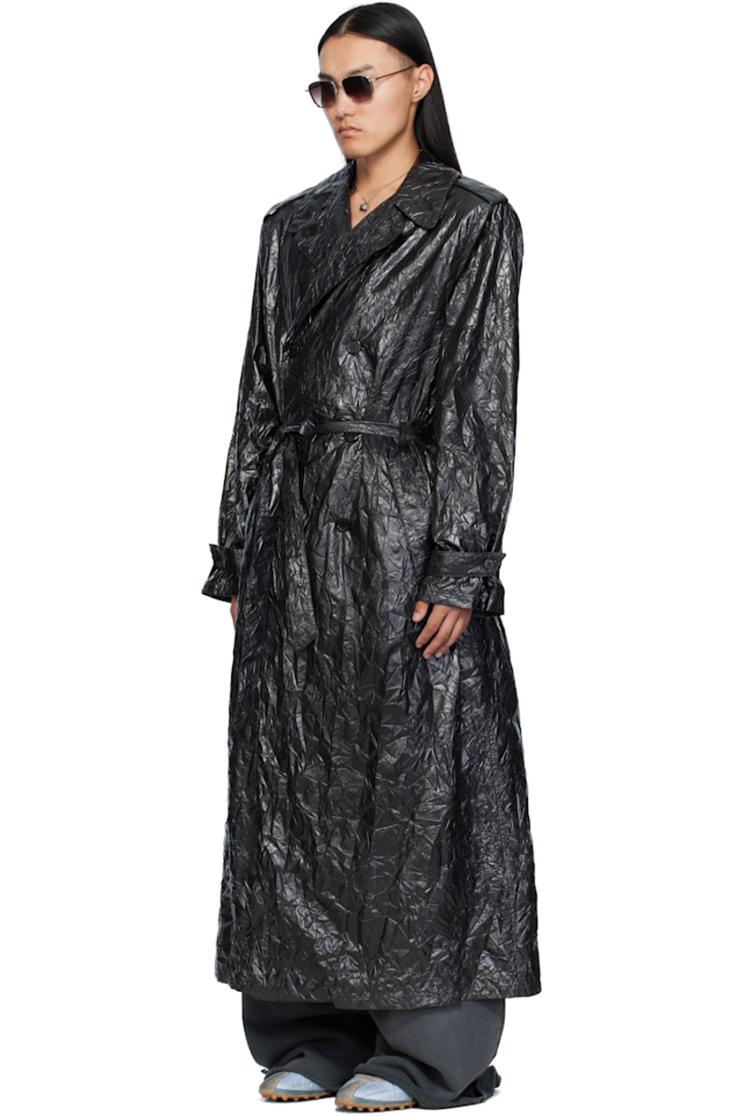 Coated crinkled nylon trench coat. 

· Peaked lapel 
· Double-breasted button closure
· Belt loops and detachable self-tie belt 
· Welt pockets at waist
· Epaulets at padded shoulders
· Central vent at back hem 

Supplier color: Black