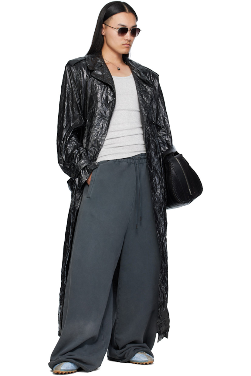 Coated crinkled nylon trench coat. 

· Peaked lapel 
· Double-breasted button closure
· Belt loops and detachable self-tie belt 
· Welt pockets at waist
· Epaulets at padded shoulders
· Central vent at back hem 

Supplier color: Black