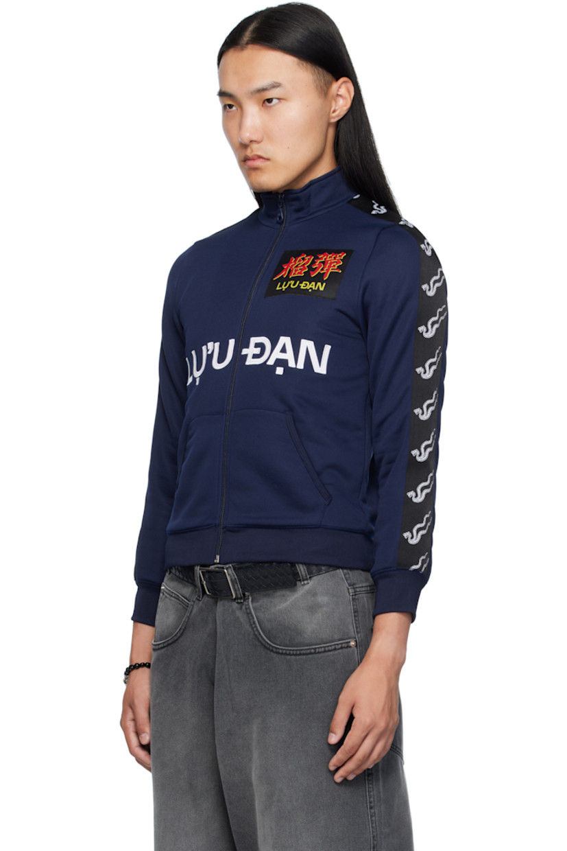 Jersey track jacket. 

· Stand collar 
· Zip closure
· Logo patch at chest
· Embroidered logo appliqués and patch pockets at front 
· Rib-knit hem and cuffs
· Jacquard logo trim at sleeves

Supplier color: Deep navy