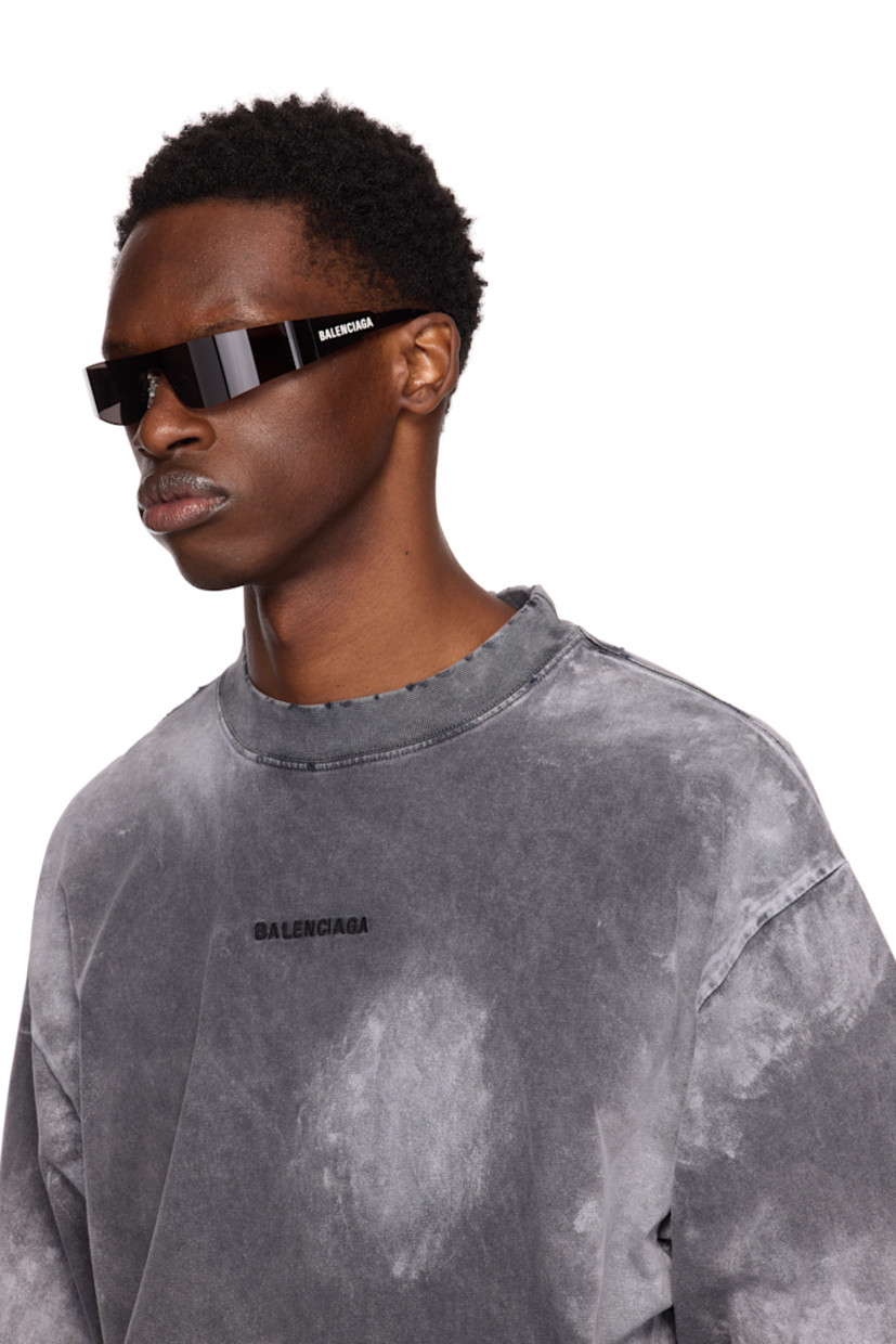 Wraparound rimless acetate-frame sunglasses in black. 

· Gray lens
· 100% UVA/UVB protection, category 1 
· Adjustable rubber nose pads
· Logo printed at temple 
· Includes case
· Size: 125

Supplier color: Grey/Grey/Grey