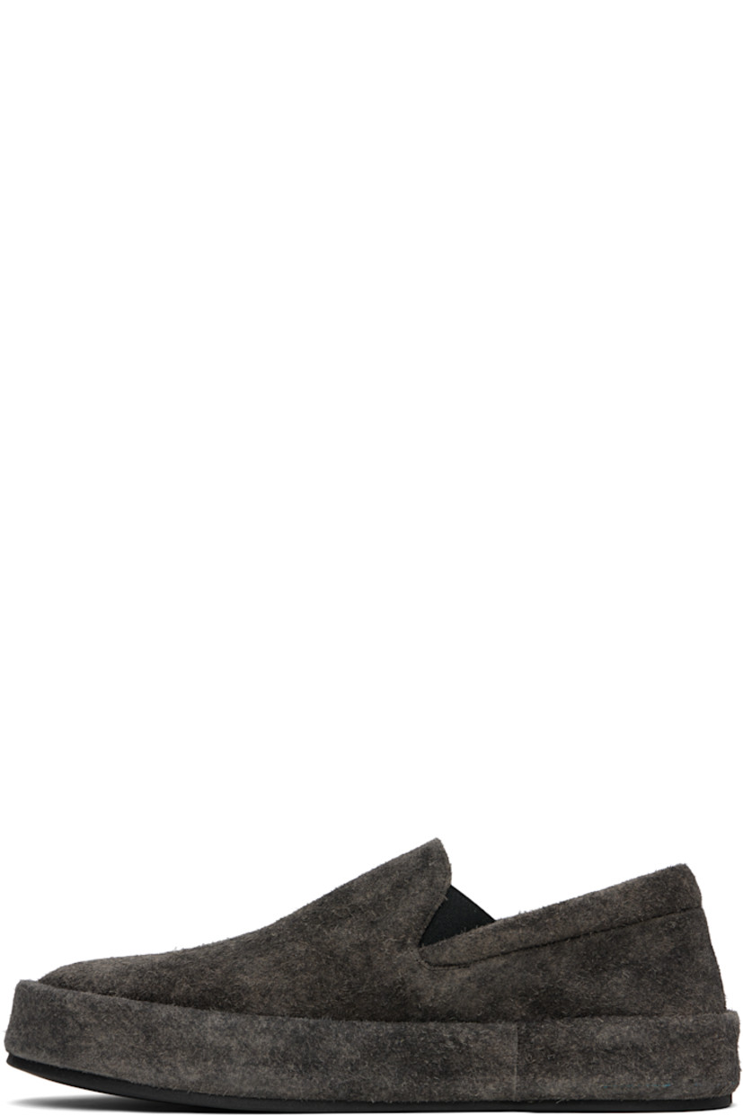 Low-top suede slip-on sneakers.

· Padded collar
· Elasticized gusset at sides
· Buffed leather lining
· Rubber sole

Supplier color: Black