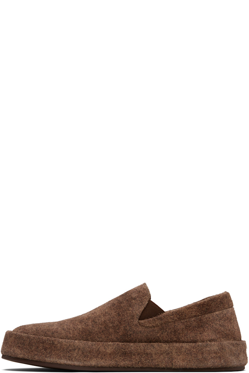 Low-top suede slip-on sneakers.

· Padded collar
· Elasticized gusset at sides
· Buffed leather lining
· Rubber sole

Supplier color: Dark brown