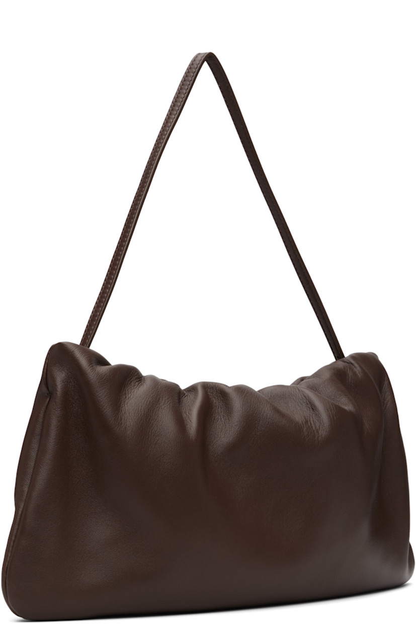 Buffed lambskin shoulder bag.

· Adjustable shoulder strap
· Logo embossed at face
· Gathering at zip closure
· Zip pocket at interior
· Buffed leather lining
· H7" x W12.5" x D1.5"

Supplier color: Brown melange