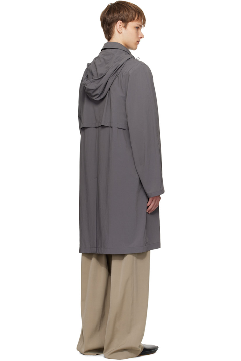 Crinkled nylon taffeta coat.

· Cord-lock drawstring at stowaway hood
· Spread collar 
· Button closure
· Welt pockets at waist
· Storm flap at back
· Zip pocket with detachable elasticized belt at back waist

Supplier color: Grey cobalt