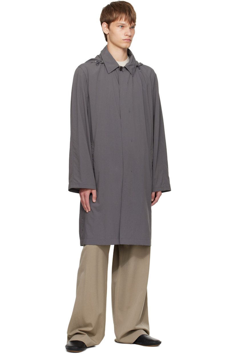 Crinkled nylon taffeta coat.

· Cord-lock drawstring at stowaway hood
· Spread collar 
· Button closure
· Welt pockets at waist
· Storm flap at back
· Zip pocket with detachable elasticized belt at back waist

Supplier color: Grey cobalt