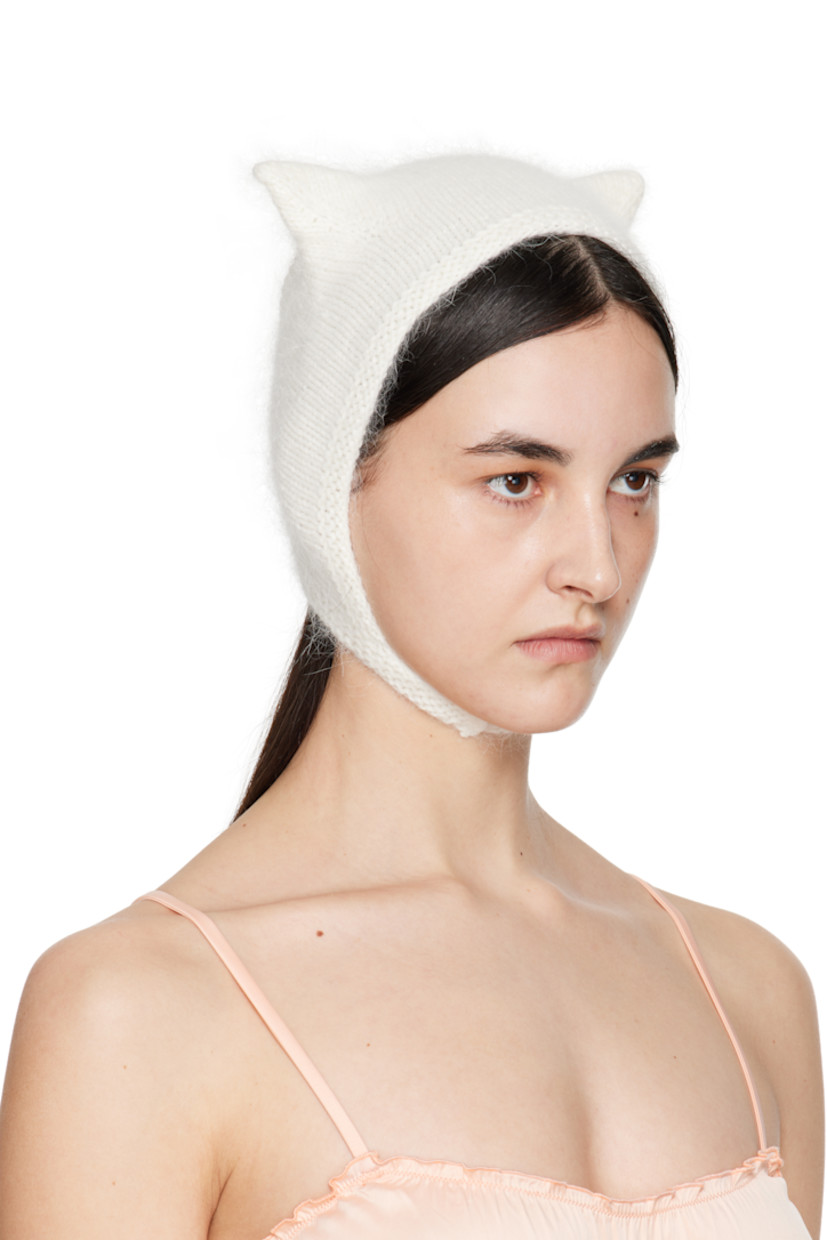 Brushed knit mink wool beanie in white.

· Ear appliqués at crown
· Hook-eye chin strap

Supplier color: White

100% mink wool.