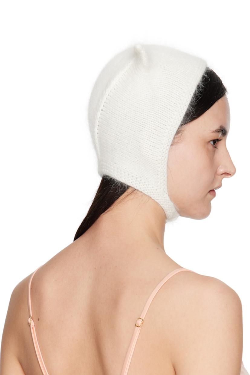 Brushed knit mink wool beanie in white.

· Ear appliqués at crown
· Hook-eye chin strap

Supplier color: White

100% mink wool.