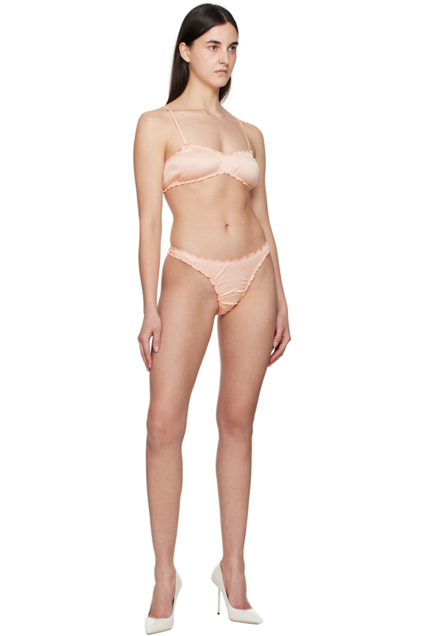 Stretch nylon satin thong. Ruffled edges and ruching throughout.

· Elasticized waistband
· Partial jersey lining

Supplier color: Coral