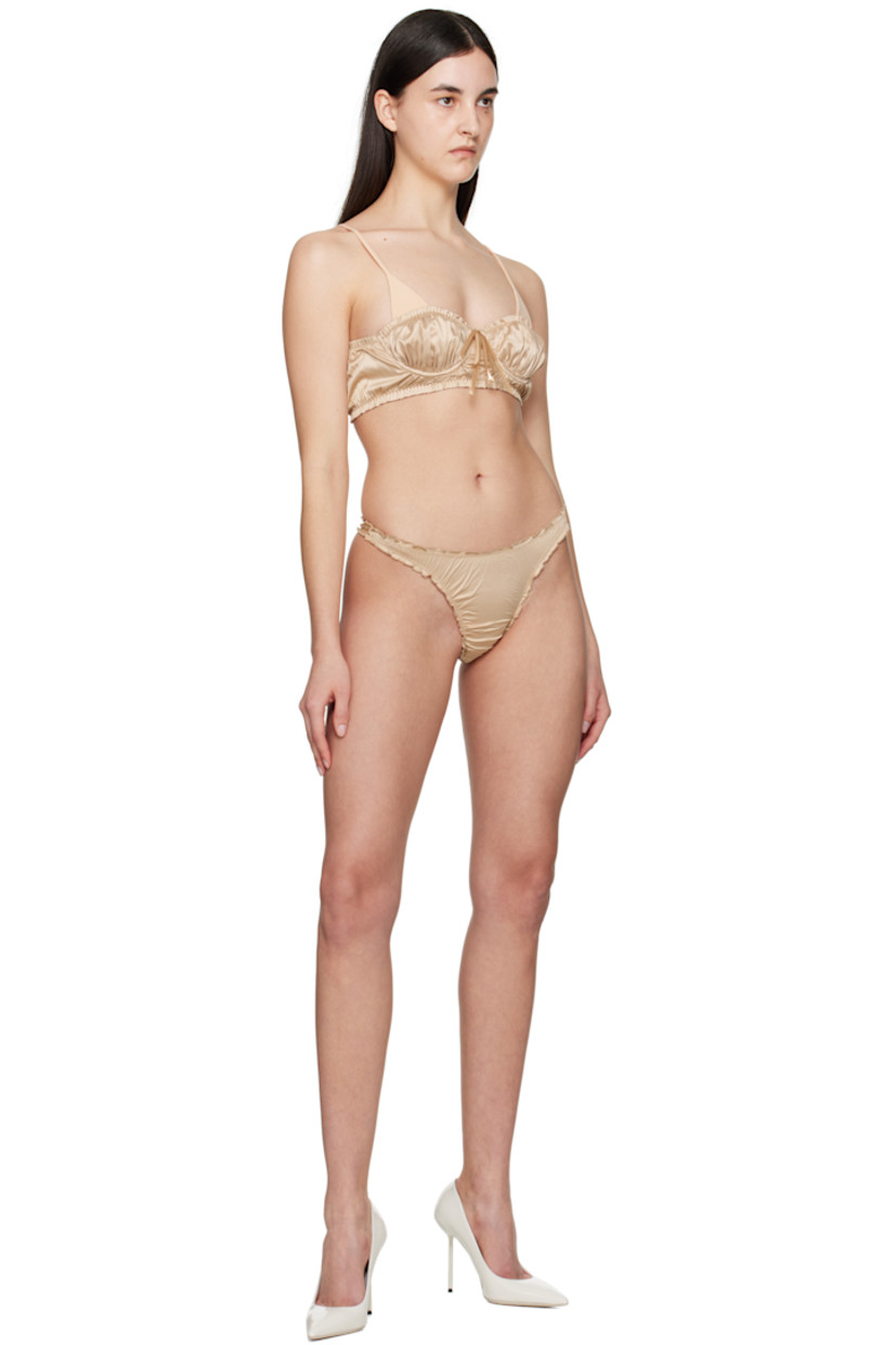Stretch nylon satin thong. Ruffled edges and ruching throughout.

· Elasticized waistband
· Partial jersey lining

Supplier color: Golden beige