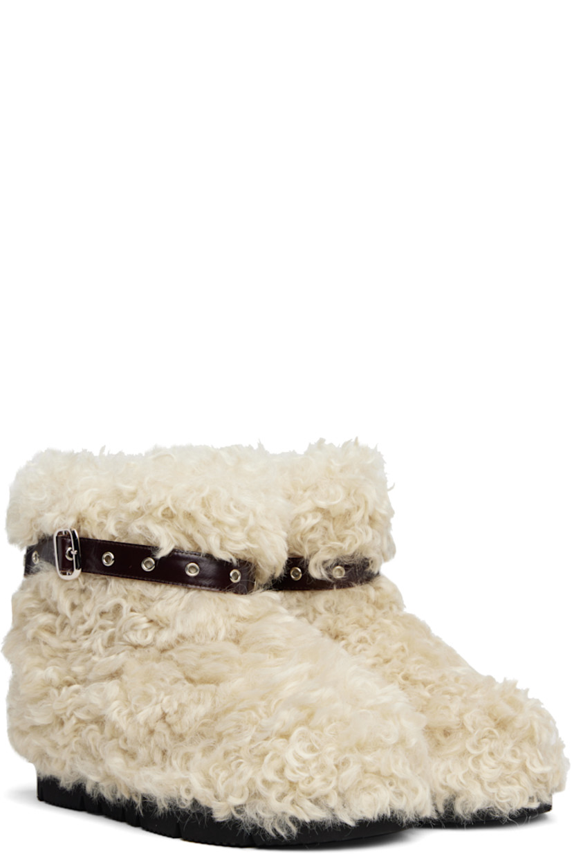Ankle-high faux-fur boots.

· Patent faux-leather pin-buckle strap at collar 
· Padded footbed
· Treaded rubber sole 

Supplier color: Beige sheep