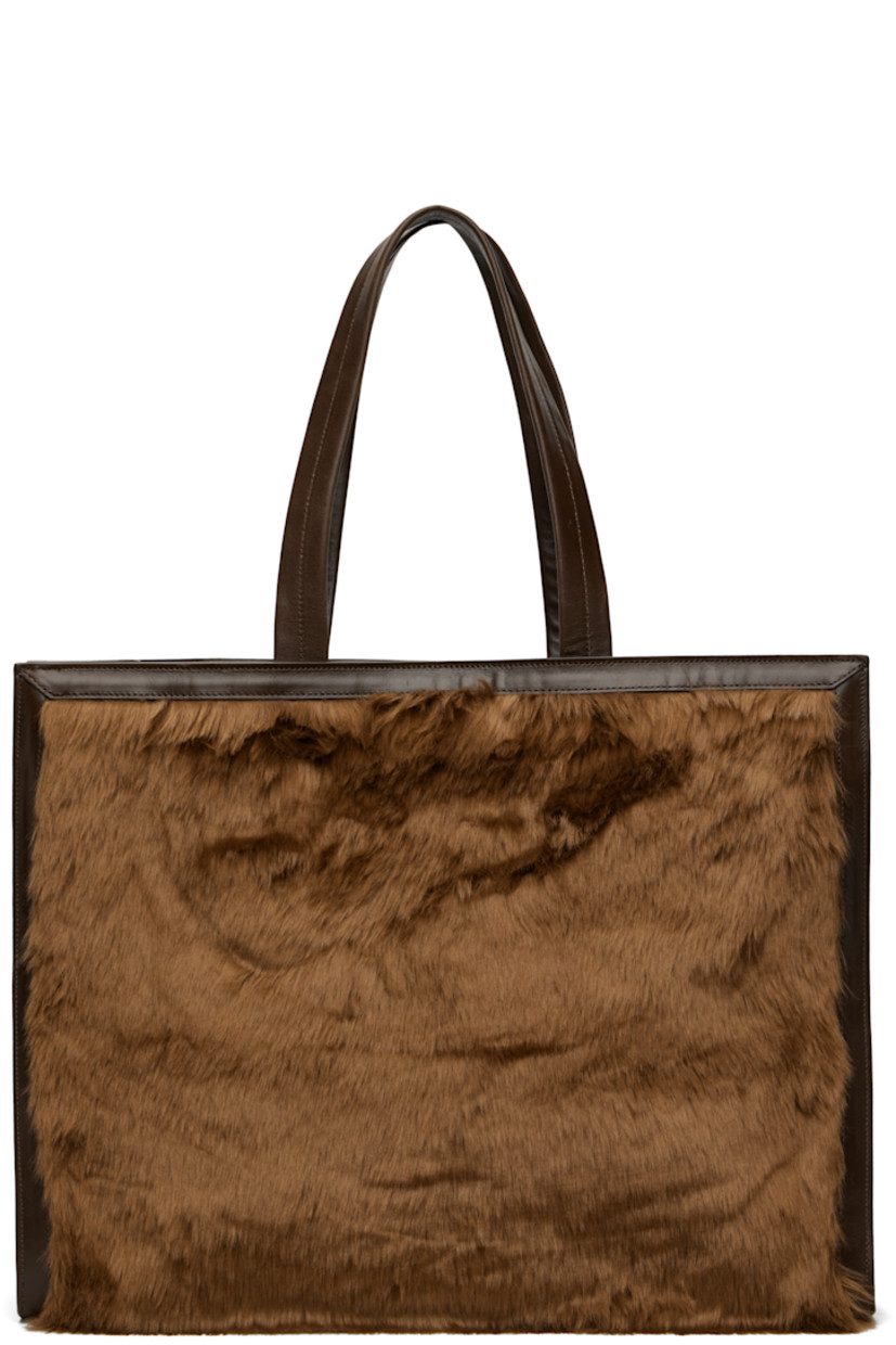 Faux-fur and buffed faux-leather tote.

· Leather shoulder straps
· Press-stud tab fastening at throat
· Detachable pouch with press-stud fastening at interior
· Pouch features four card slots and one note slot
· Alternate press-stud fastening at face
· Patch pocket at interior
· Twill lining
· H14" x W18" x D6"

Supplier color: Brown