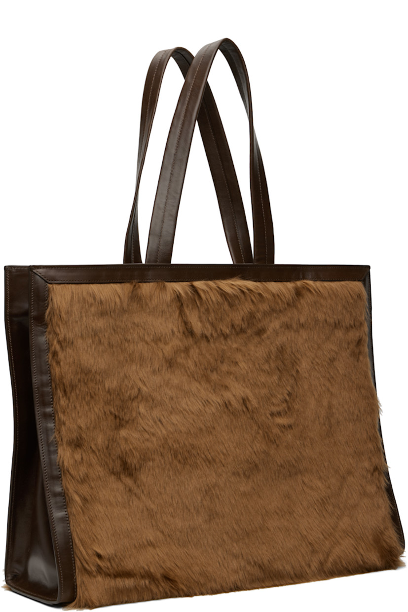 Faux-fur and buffed faux-leather tote.

· Leather shoulder straps
· Press-stud tab fastening at throat
· Detachable pouch with press-stud fastening at interior
· Pouch features four card slots and one note slot
· Alternate press-stud fastening at face
· Patch pocket at interior
· Twill lining
· H14" x W18" x D6"

Supplier color: Brown