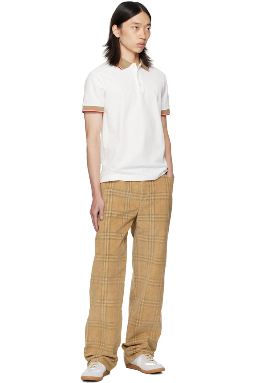 Cotton piqué polo.

· Jacquard logo at spread collar
· Stripes at collar and cuffs
· Three-button placket
· Tennis-tail hem

Supplier color: Chalk