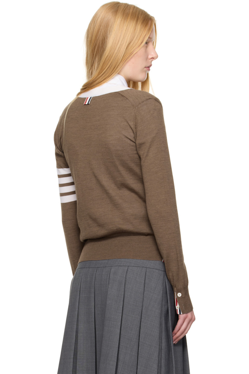 Knit virgin wool cardigan. Concealed tricolor grosgrain trim throughout.

· Rib-knit Y-neck, hem, and cuffs
· Button closure
· Patch pockets
· Button vent at side seams and cuffs
· Stripes at sleeve
· Tricolor grosgrain flag at back collar

Supplier color: Walnut