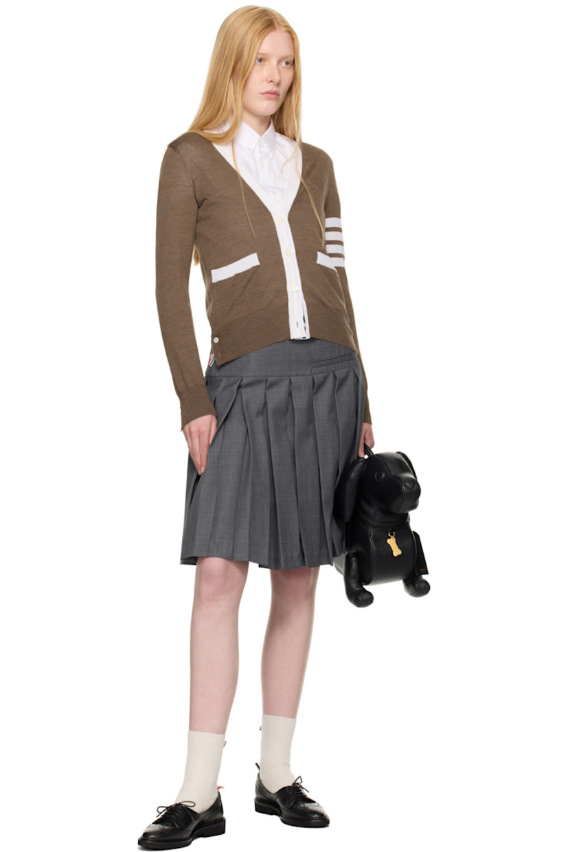 Knit virgin wool cardigan. Concealed tricolor grosgrain trim throughout.

· Rib-knit Y-neck, hem, and cuffs
· Button closure
· Patch pockets
· Button vent at side seams and cuffs
· Stripes at sleeve
· Tricolor grosgrain flag at back collar

Supplier color: Walnut