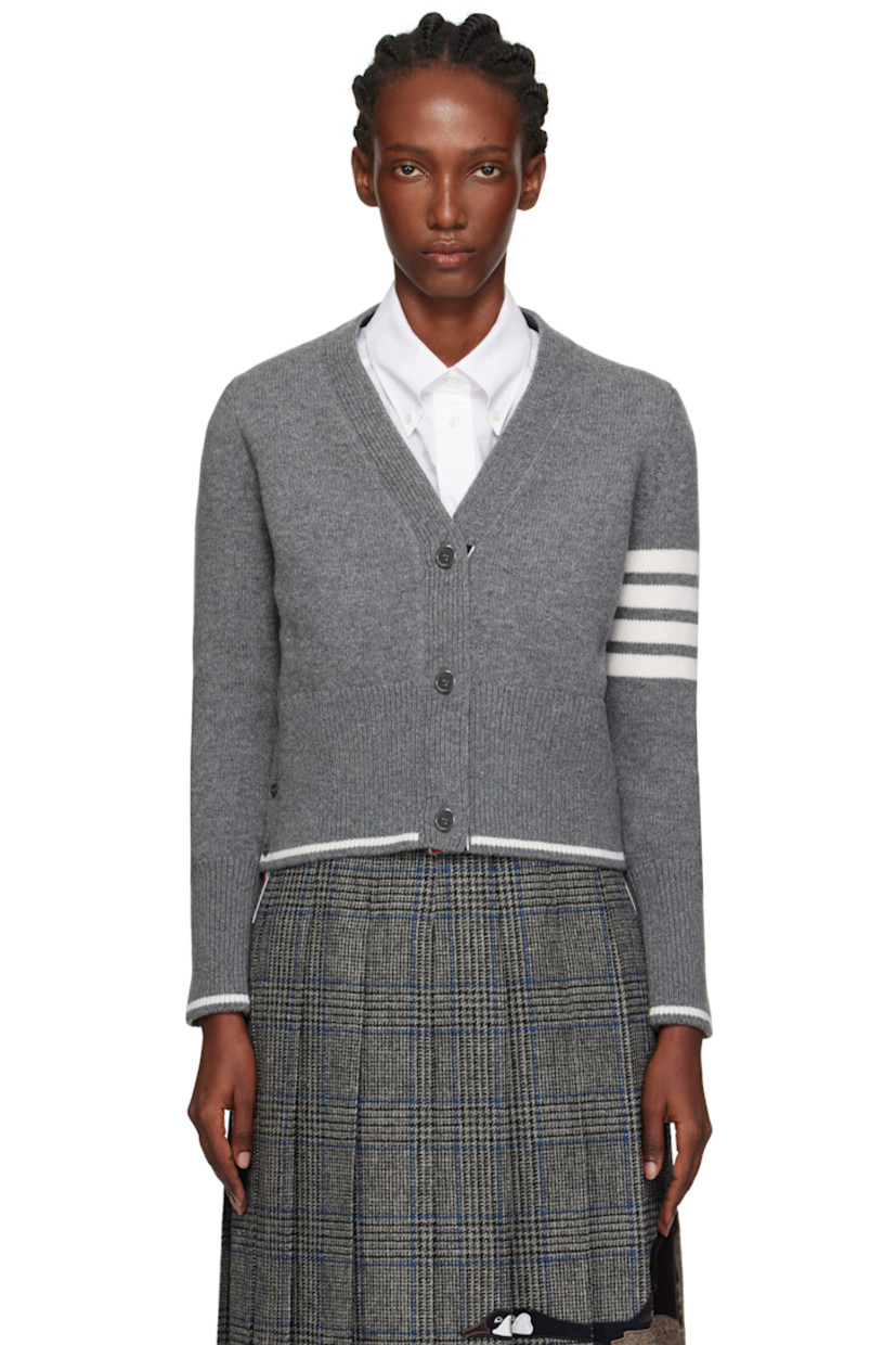 Knit virgin wool cardigan.

· Rib-knit V-neck, hem, and cuffs
· Button closure
· Intarsia stripe at hem and cuffs
· Buttoned vent at side seams
· Droptail hem 
· Intarsia stripes at sleeve
· Tricolor grosgrain flag at back collar 
· Intarsia graphics at back

Supplier color: Med grey