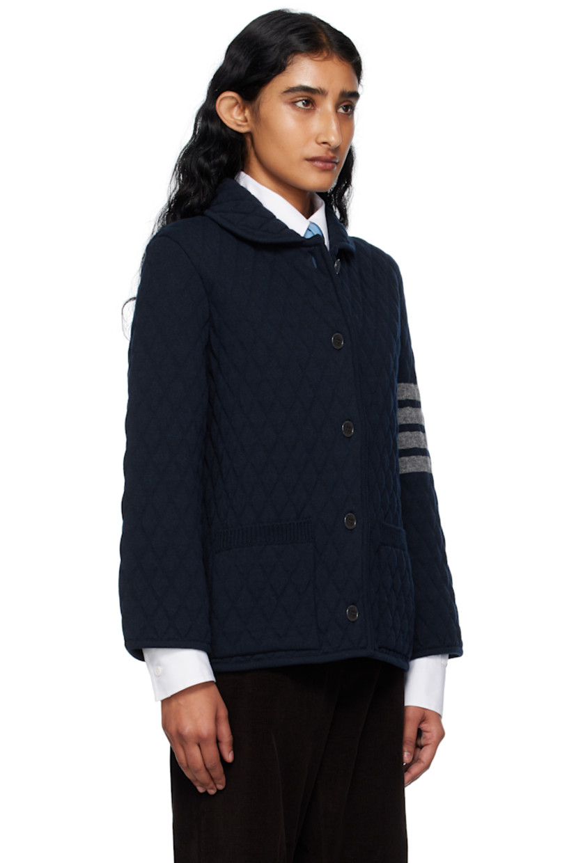 Insulated knit virgin wool jacket. 

· Embossed pattern throughout
· Rib-knit edge at shawl collar, hem, and cuffs
· Button closure
· Patch pockets at waist
· Jacquard stripes at sleeve
· Tricolor loop at back collar
· Knit lining

Supplier color: Navy