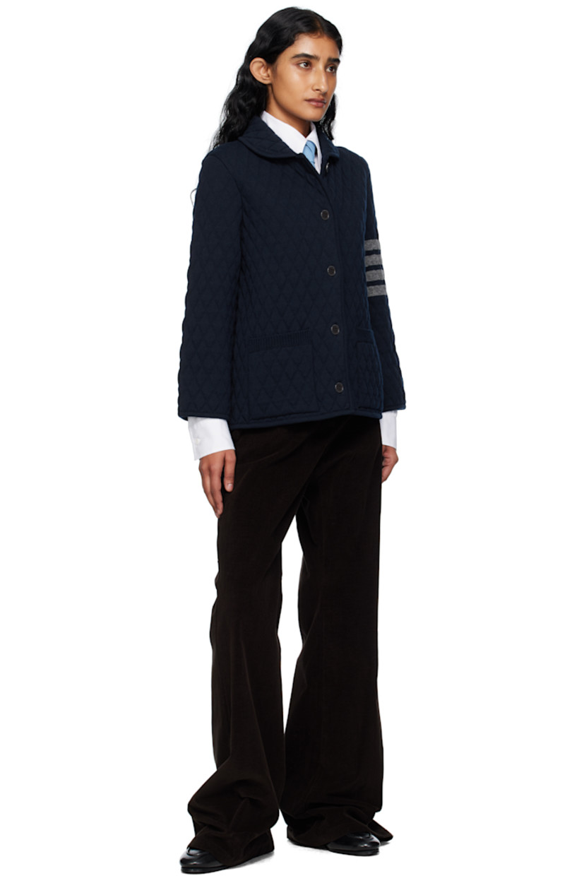 Insulated knit virgin wool jacket. 

· Embossed pattern throughout
· Rib-knit edge at shawl collar, hem, and cuffs
· Button closure
· Patch pockets at waist
· Jacquard stripes at sleeve
· Tricolor loop at back collar
· Knit lining

Supplier color: Navy