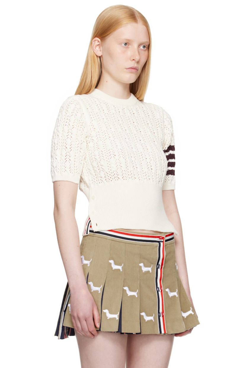 Pointelle-knit cotton sweater. Cable-knit detailing throughout.

· Rib-knit crewneck, hem, and cuffs
· Button vent at side seams with tricolor grosgrain trim
· Intarsia stripes at sleeve
· Tricolor grosgrain flag at back collar

Supplier color: White