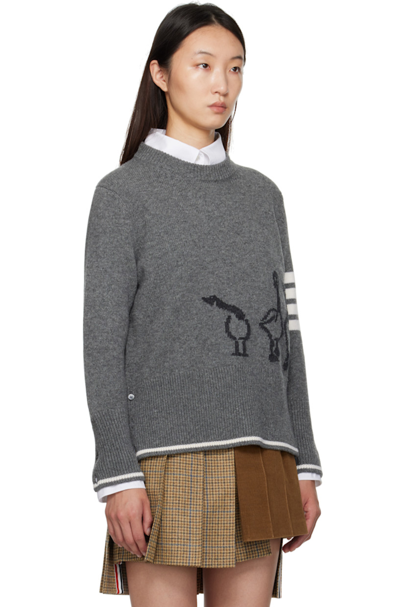 Knit virgin wool sweater.

· Rib-knit crewneck, hem, and cuffs
· Intarsia graphic at front
· Intarsia stripes at sleeve
· Buttoned vent at hem
· Tricolor loop at back collar
· Intarsia stripe at hem and cuffs

Supplier color: Med Grey