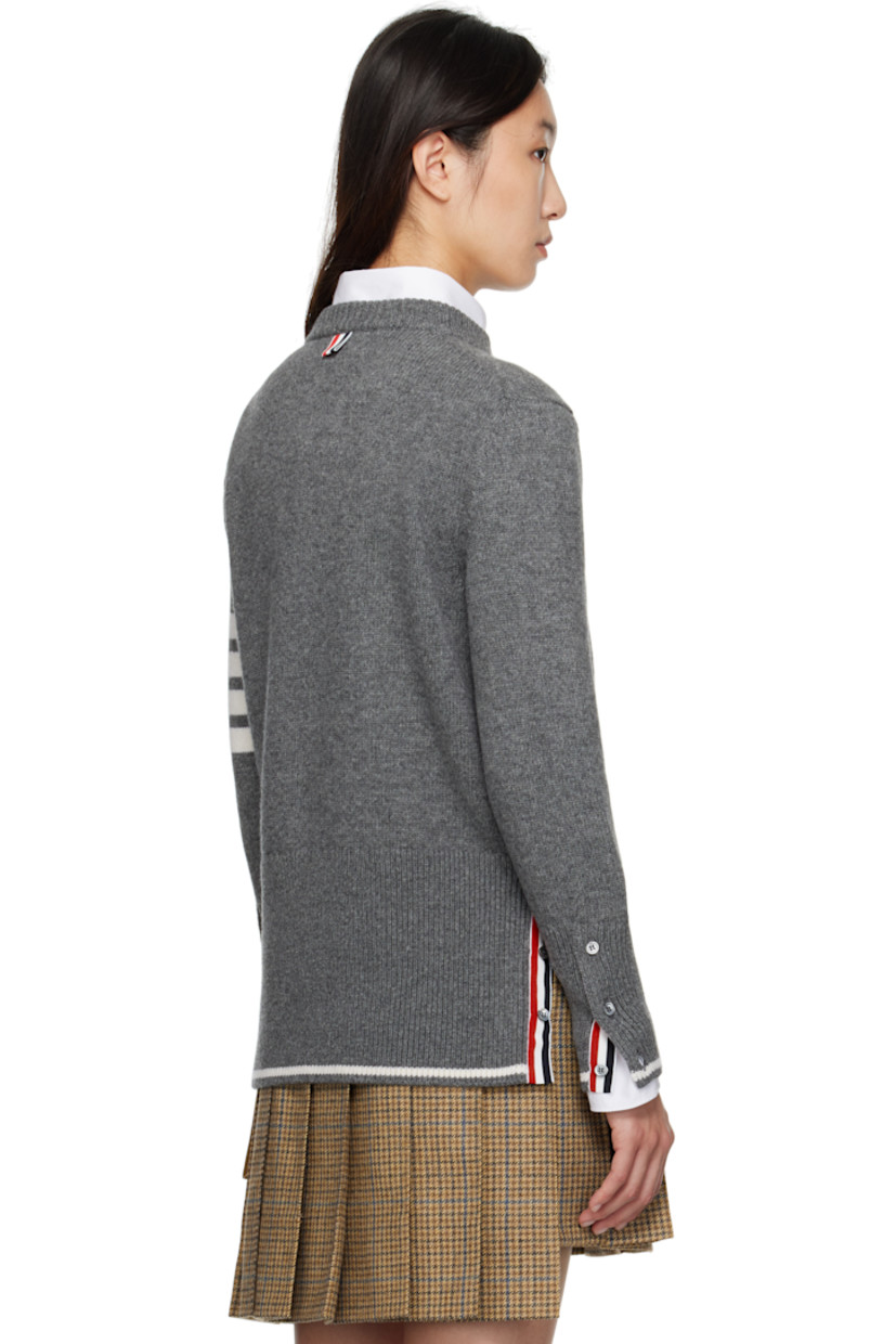 Knit virgin wool sweater.

· Rib-knit crewneck, hem, and cuffs
· Intarsia graphic at front
· Intarsia stripes at sleeve
· Buttoned vent at hem
· Tricolor loop at back collar
· Intarsia stripe at hem and cuffs

Supplier color: Med Grey
