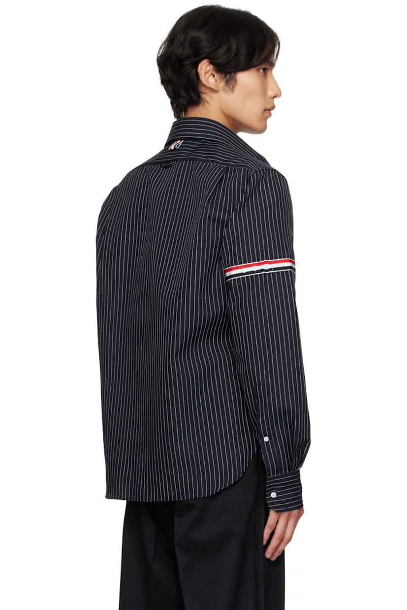 Virgin wool-blend canvas shirt. 

· Pinstripes throughout 
· Button tab at spread collar 
· Zip closure
· Patch pocket at front 
· Shirttail hem 
· Tricolor grosgrain appliqué at sleeve
· Buttoned barrel cuffs
· Tricolor grosgrain flag at back collar 
· Locker loop and twin pleats at back yoke 

Supplier color: Navy