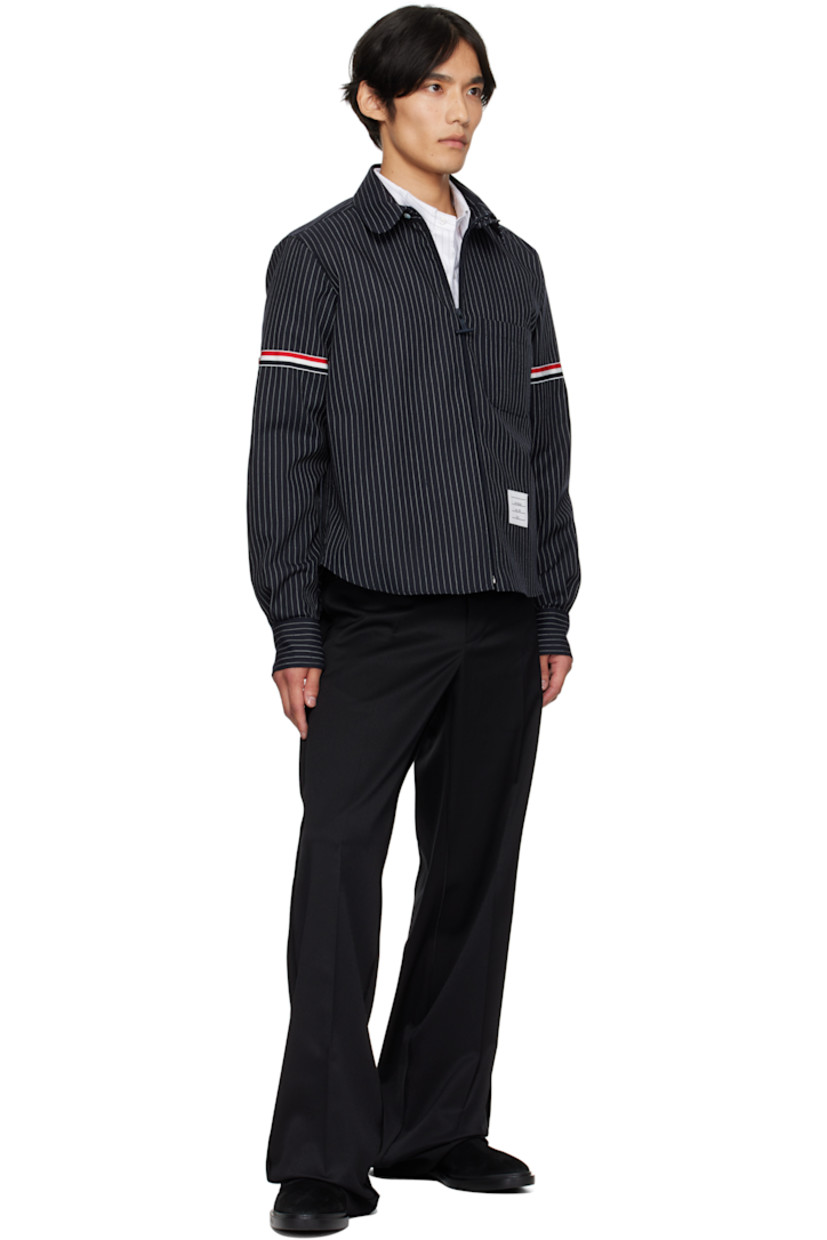 Virgin wool-blend canvas shirt. 

· Pinstripes throughout 
· Button tab at spread collar 
· Zip closure
· Patch pocket at front 
· Shirttail hem 
· Tricolor grosgrain appliqué at sleeve
· Buttoned barrel cuffs
· Tricolor grosgrain flag at back collar 
· Locker loop and twin pleats at back yoke 

Supplier color: Navy