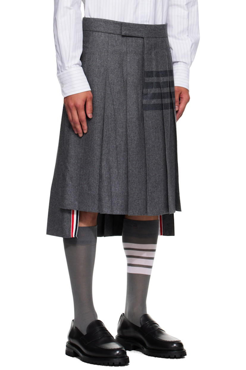 Felted wool-blend flannel skirt.

· Knife pleats throughout
· Button fly
· Droptail hem
· Stripes printed at side
· Tricolor grosgrain trim at vented side seams
· Tricolor grosgrain flag and adjustable button tab at back
· Full cupro satin lining

Supplier color: Med grey