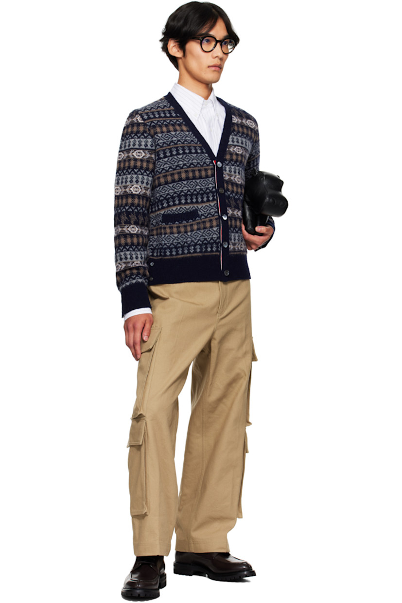 Brushed knit wool cardigan.

· Jacquard graphic pattern throughout
· Tricolor trim at placket and vents
· V-neck
· Button closure
· Patch pockets at waist
· Rib-knit hem and cuffs
· Button vent at side seams and cuffs
· Tricolor grosgrain flag at back collar

Supplier color: Navy