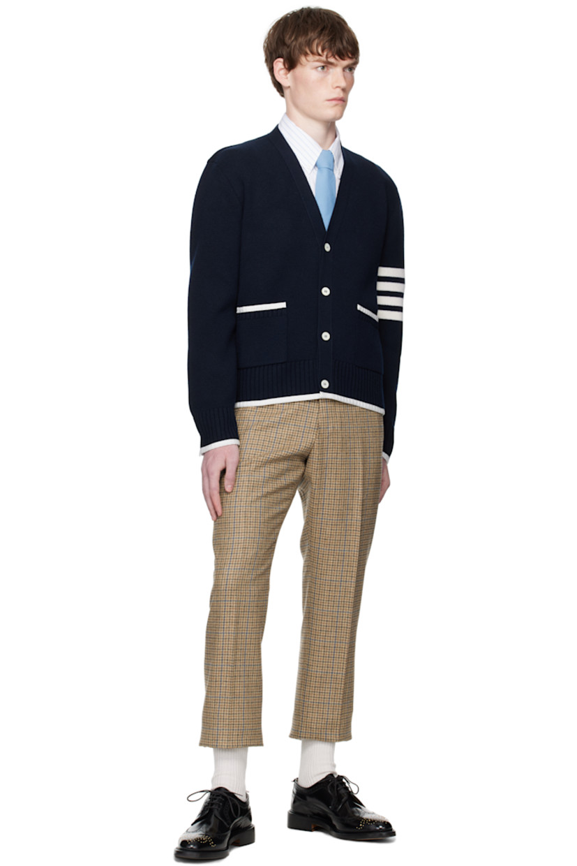 Knit virgin wool cardigan.

· Grosgrain trim throughout
· Rib-knit Y-neck, hem, and cuffs
· Button closure
· Patch pockets at waist
· Button vent at side seams and cuffs
· Stripes at sleeve
· Tricolor grosgrain flag at back collar

Supplier color: Navy