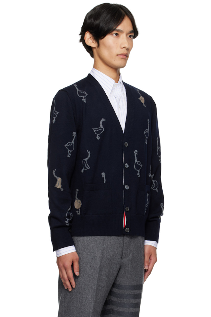 Merino wool-blend piqué cardigan.

· Intarsia graphic pattern throughout
· Rib-knit V-neck, cuffs, and hem
· Button closure with concealed striped grosgrain placket
· Tricolor grosgrain flag at back collar

Supplier color: Roman