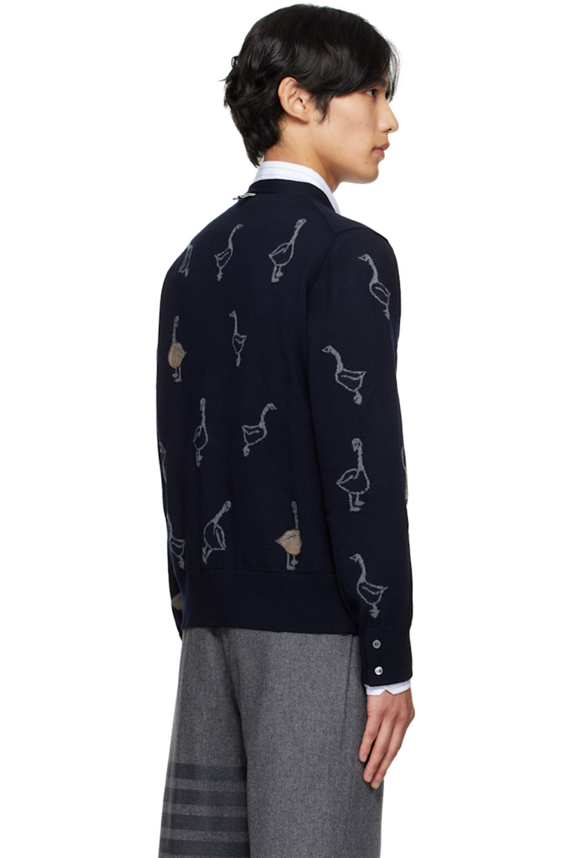 Merino wool-blend piqué cardigan.

· Intarsia graphic pattern throughout
· Rib-knit V-neck, cuffs, and hem
· Button closure with concealed striped grosgrain placket
· Tricolor grosgrain flag at back collar

Supplier color: Roman