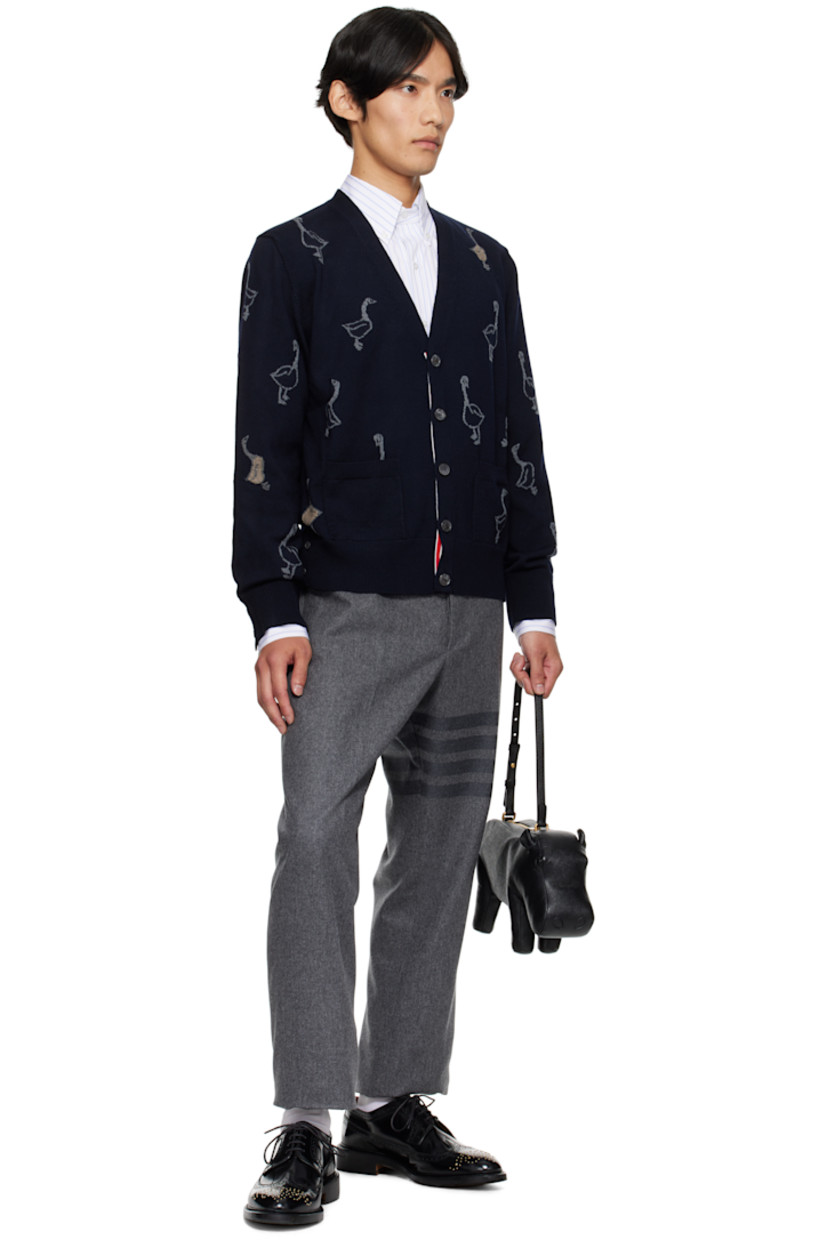 Merino wool-blend piqué cardigan.

· Intarsia graphic pattern throughout
· Rib-knit V-neck, cuffs, and hem
· Button closure with concealed striped grosgrain placket
· Tricolor grosgrain flag at back collar

Supplier color: Roman