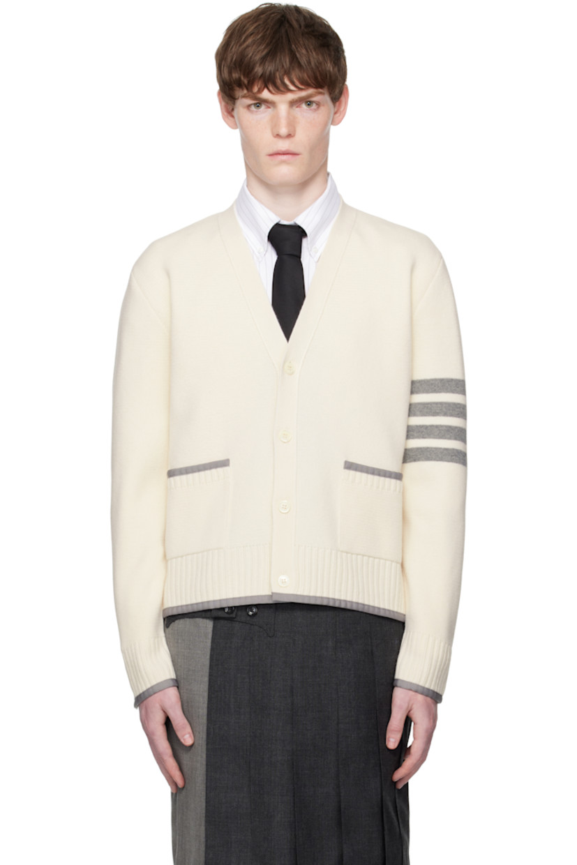 Knit virgin wool cardigan.

· Grosgrain trim throughout
· Rib-knit Y-neck, hem, and cuffs
· Button closure
· Patch pockets at waist
· Button vent at side seams and cuffs
· Stripes at sleeve
· Tricolor grosgrain flag at back collar

Supplier color: White
