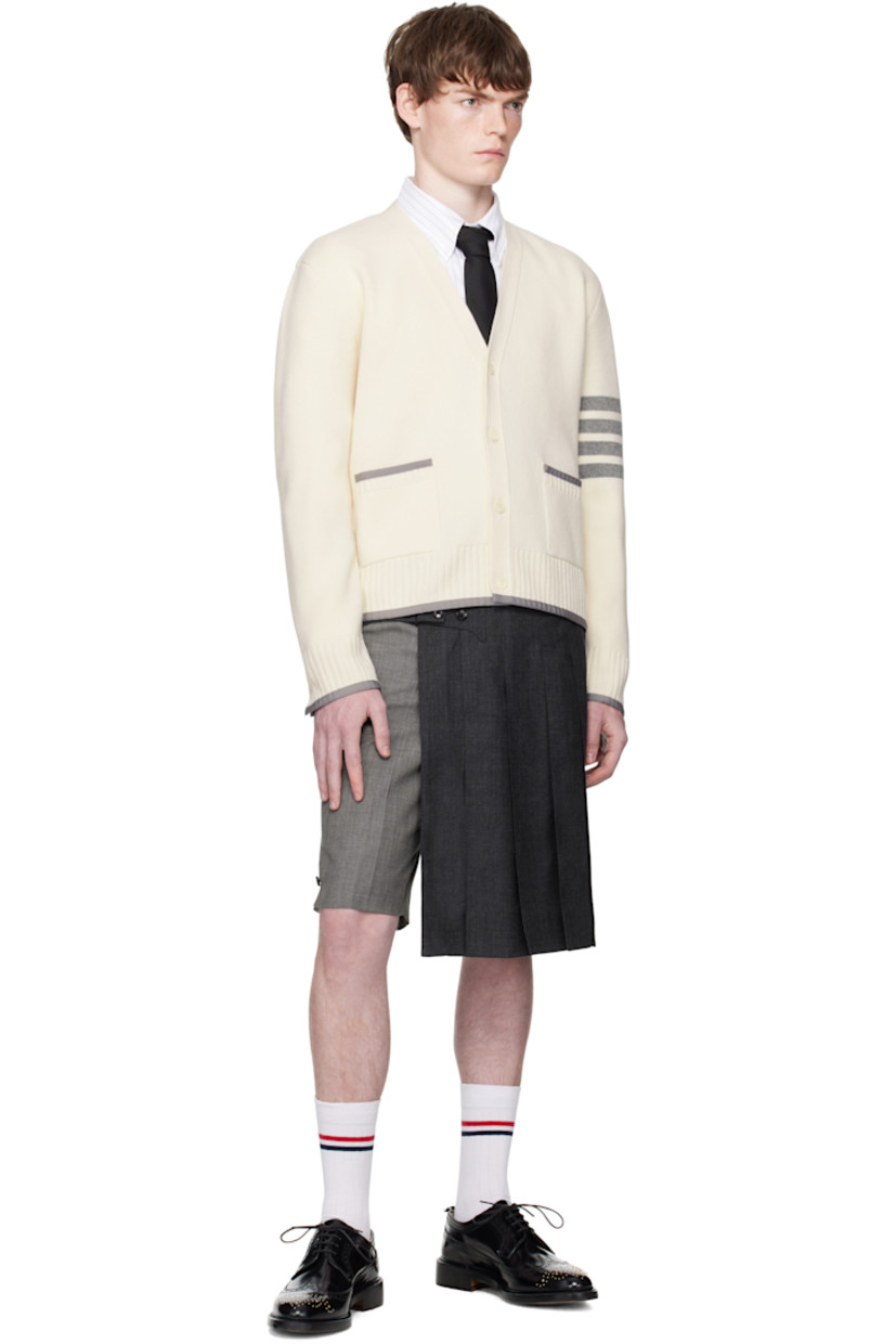 Knit virgin wool cardigan.

· Grosgrain trim throughout
· Rib-knit Y-neck, hem, and cuffs
· Button closure
· Patch pockets at waist
· Button vent at side seams and cuffs
· Stripes at sleeve
· Tricolor grosgrain flag at back collar

Supplier color: White