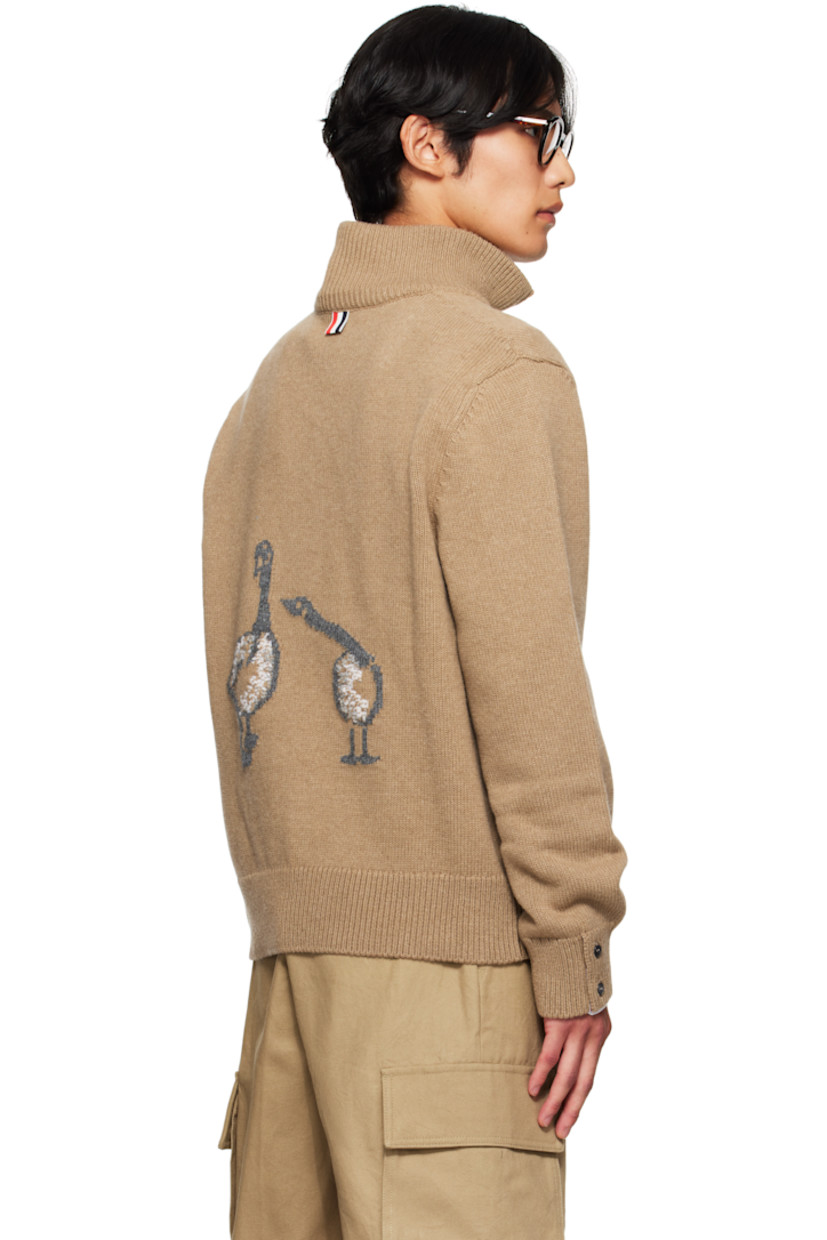 Knit virgin merino wool sweater.

· Rib-knit mock neck, hem, and cuffs
· Half-zip closure
· Button vent with tricolor trim at cuffs
· Tricolor grosgrain flag at back collar
· Intarsia graphics at back

Supplier color: Med brown