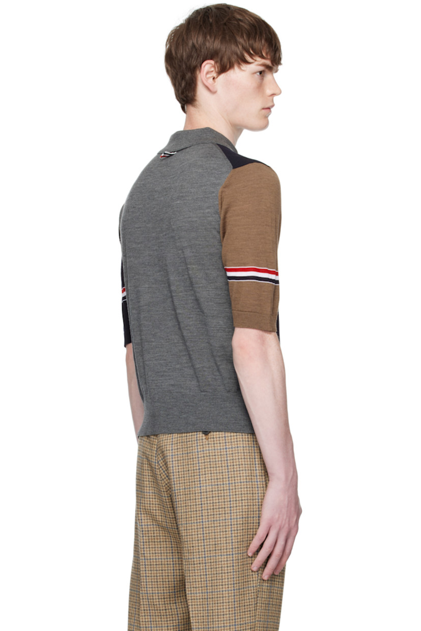 Knit virgin wool polo.

· Rib-knit spread collar, hem, and cuffs
· Five-button placket
· Button vent at side seams
· Stripes at sleeves
· Tricolor grosgrain flag at back collar

Supplier color: Navy/Grey/Brown