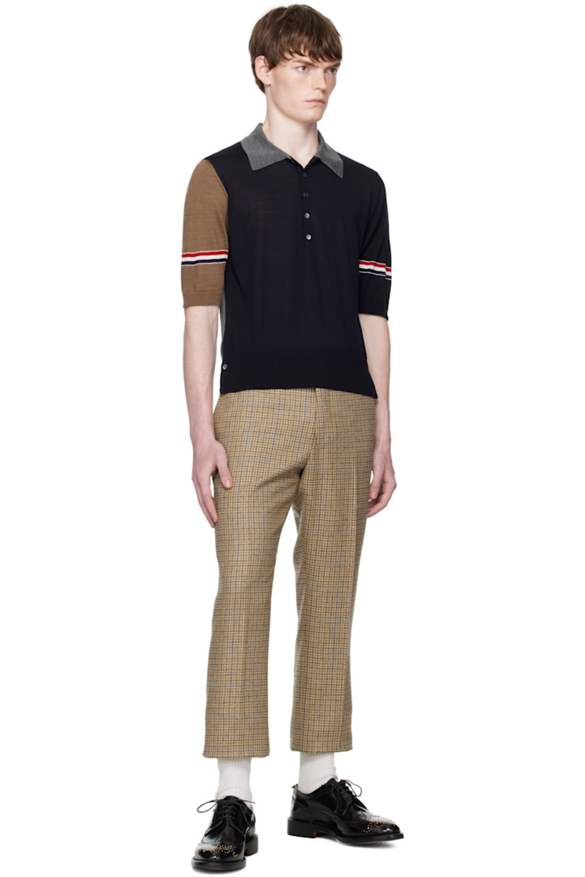 Knit virgin wool polo.

· Rib-knit spread collar, hem, and cuffs
· Five-button placket
· Button vent at side seams
· Stripes at sleeves
· Tricolor grosgrain flag at back collar

Supplier color: Navy/Grey/Brown