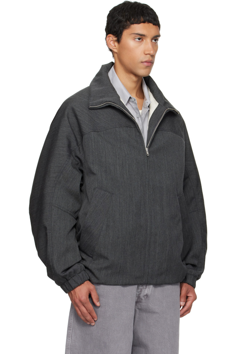 Padded virgin wool twill jacket.

· Stand collar
· Zip closure
· Press-stud welt pockets at waist
· Partially elasticized hem
· Yoke sleeves
· Elasticized cuffs
· Striped webbing strap at back collar
· Full satin twill lining

Supplier color: Concrete