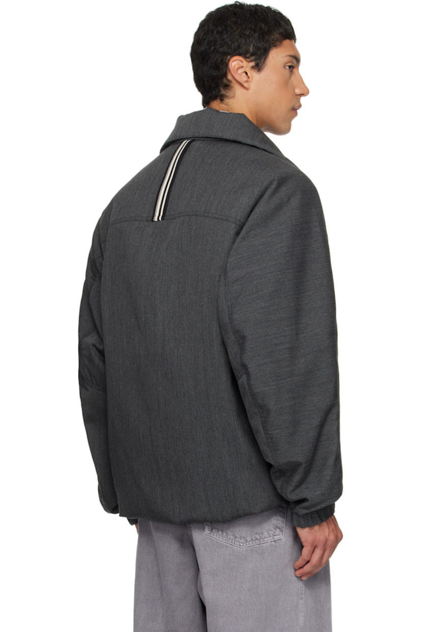 Padded virgin wool twill jacket.

· Stand collar
· Zip closure
· Press-stud welt pockets at waist
· Partially elasticized hem
· Yoke sleeves
· Elasticized cuffs
· Striped webbing strap at back collar
· Full satin twill lining

Supplier color: Concrete