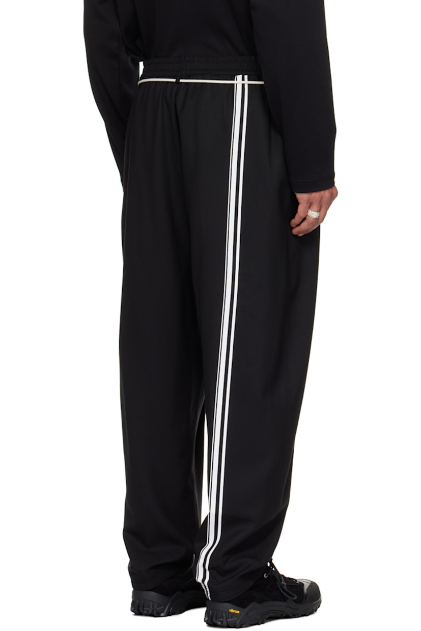Virgin wool barathea trousers.

· Belt loops at elasticized waistband
· Two-pocket styling
· Mock fly
· Drawstring at waist
· Pleats at front
· Topstitching at cuffs
· Stripes printed at back leg

Supplier color: Black